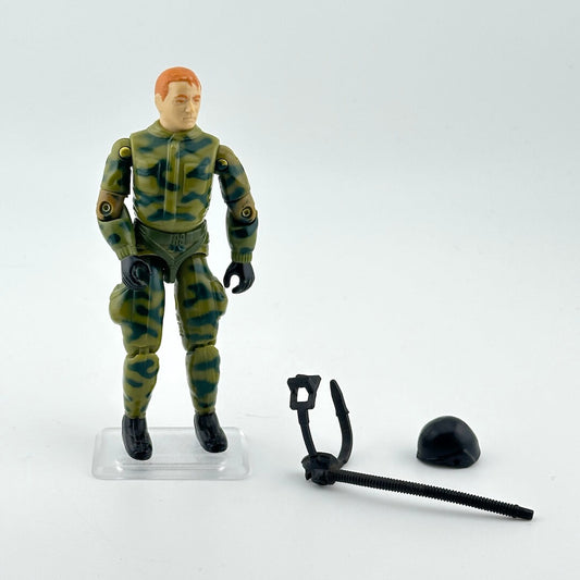 GI Joe action figure in camouflage outfit with accessories against white background. 
