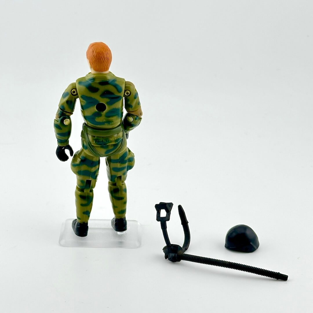 GI Joe action figure in camouflage outfit with accessories against white background. 