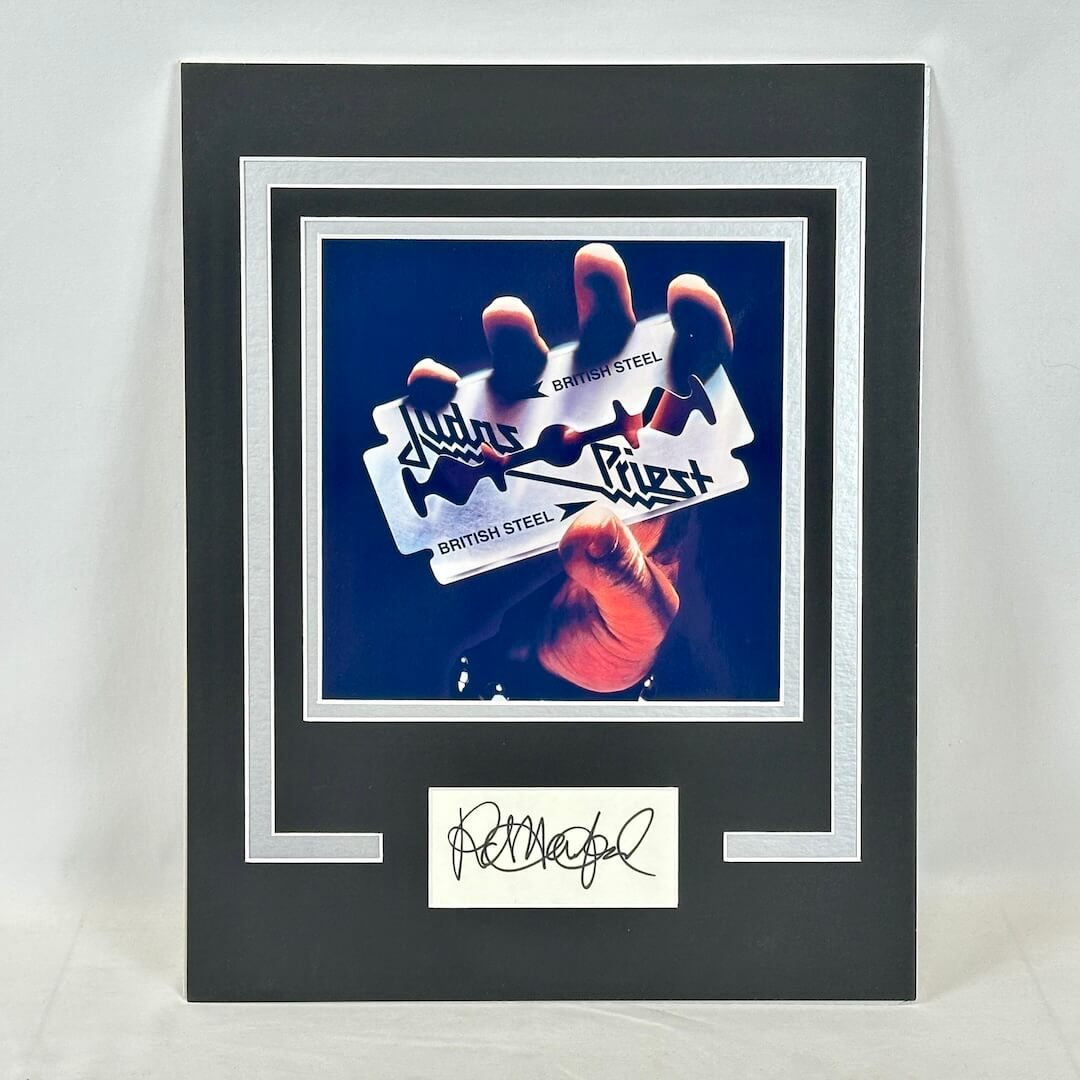 Framed display with a hand holding a 'British Steel' sign and a signature at the bottom.
