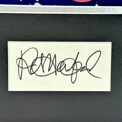 Signature on a small card with a dark background