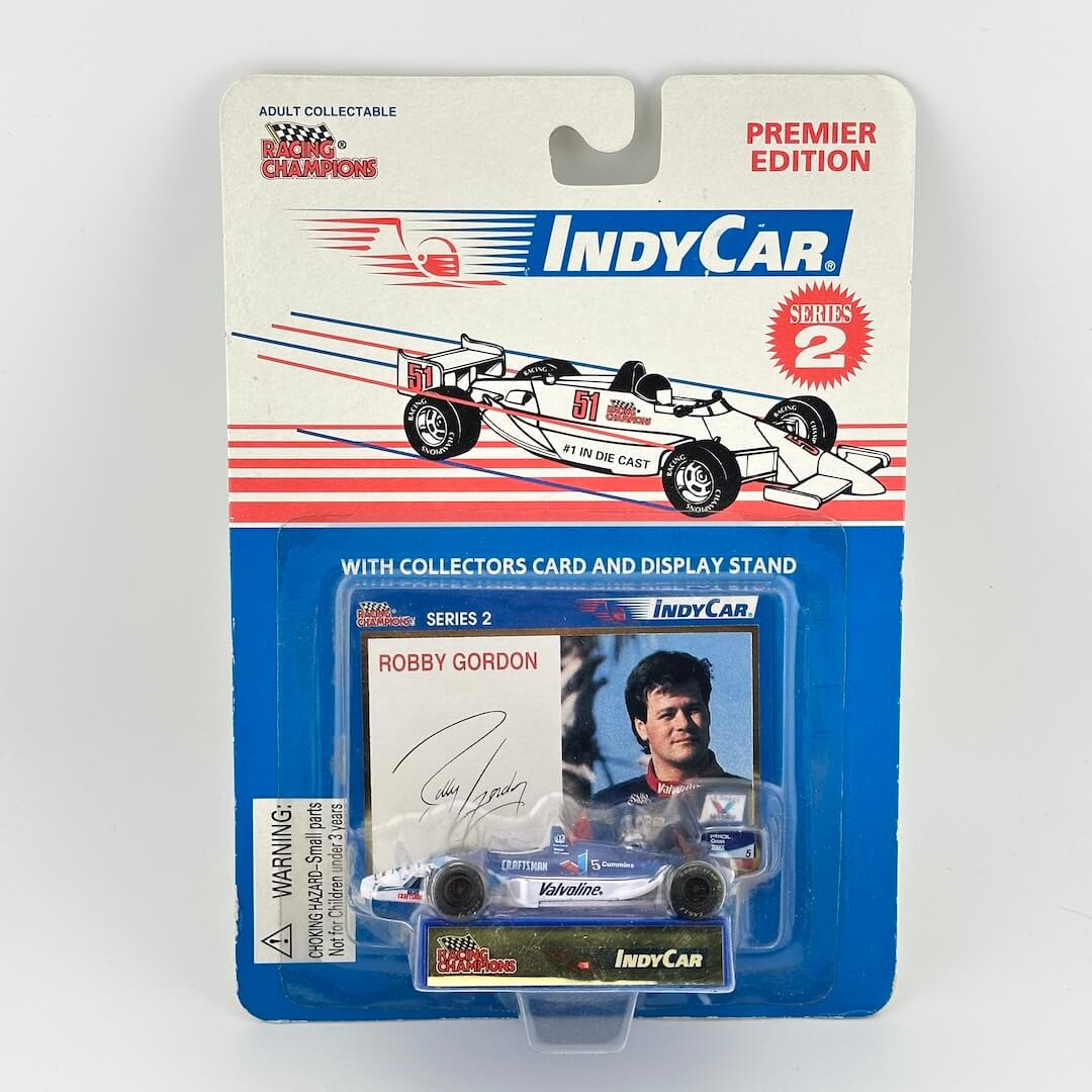 IndyCar model car packaging with card and display stand on a white background