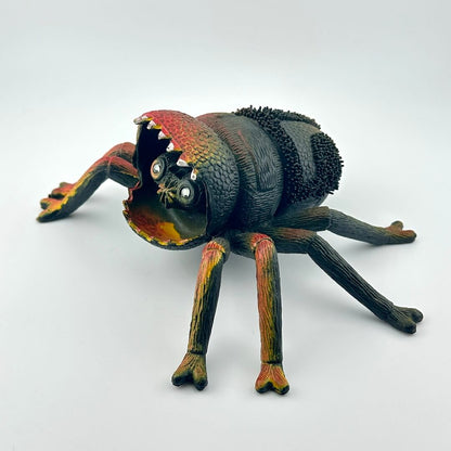 Colorful spider toy with face inside mouth, on a white background