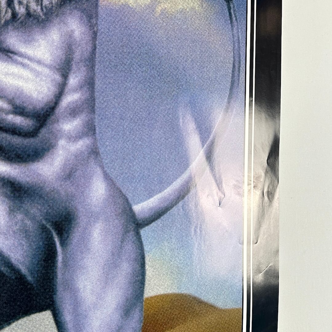 View of poster reflecting light to show dings and creases. 