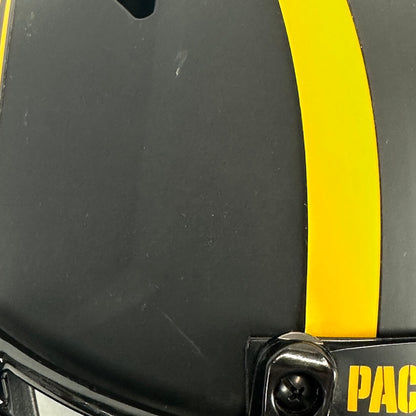 Close-up of a black helmet with a bold yellow stripe running vertically and a couple of scratches. 