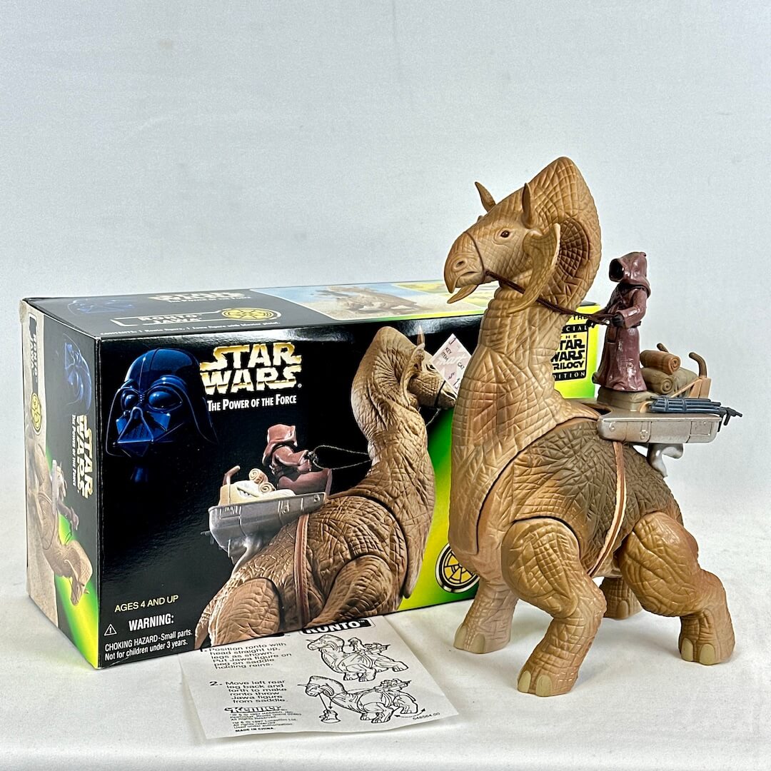 Toy figure of a creature with a character on its back, next to a 'Star Wars' toy box.
