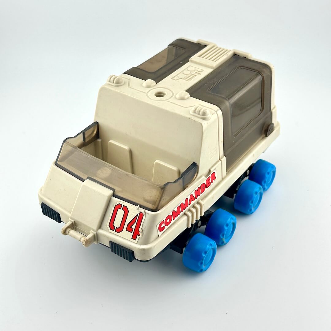 Toy moon rover with blue wheels against white background. 