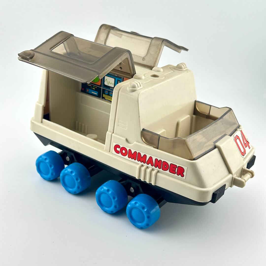 Toy moon rover with blue wheels against white background. 