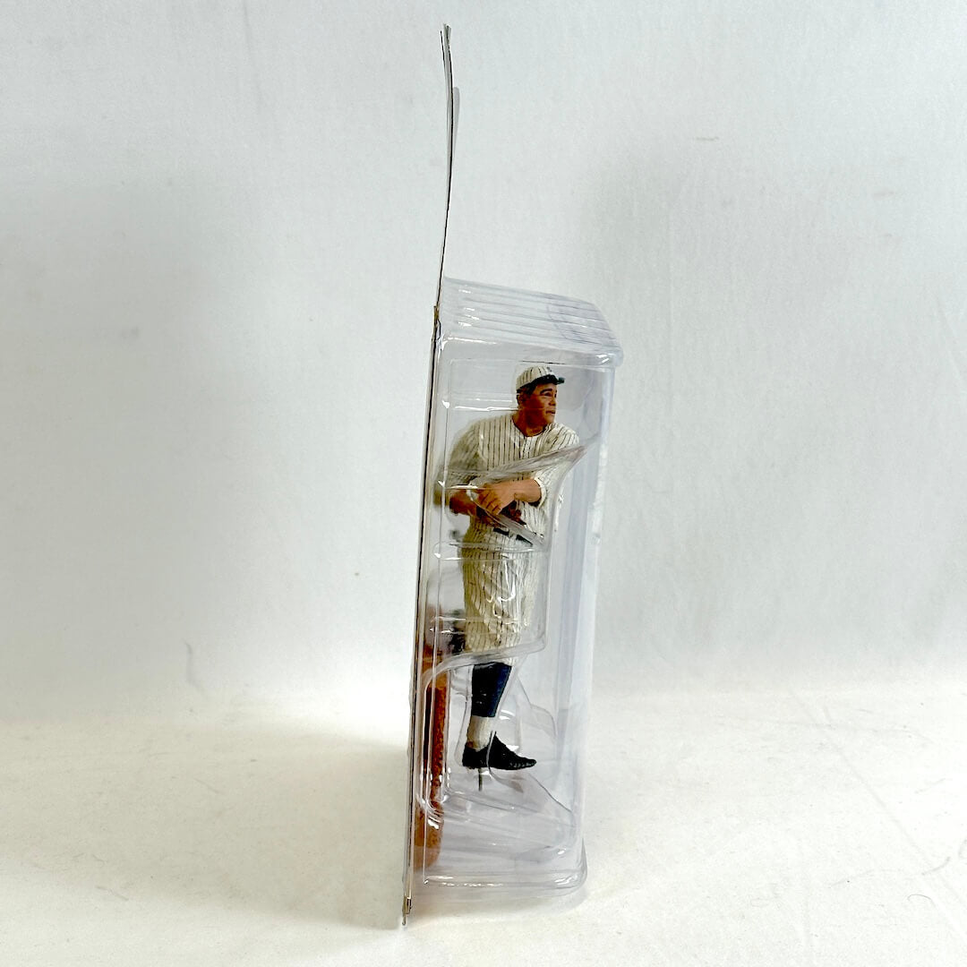 Baseball player figurine in a clear plastic packaging on a white background