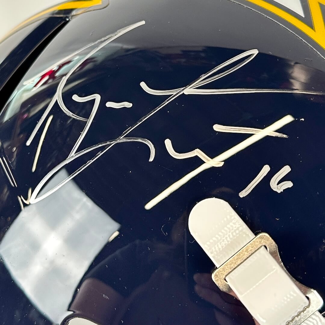 Close-up of a helmet with a signature and number on a reflective surface