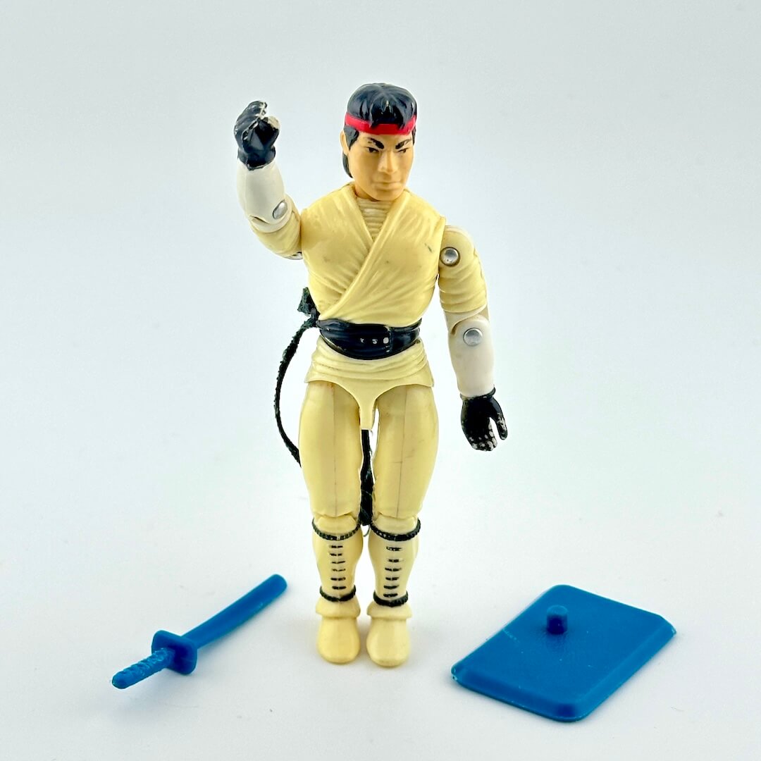 Action figure in martial arts costume with accessories against white background. 