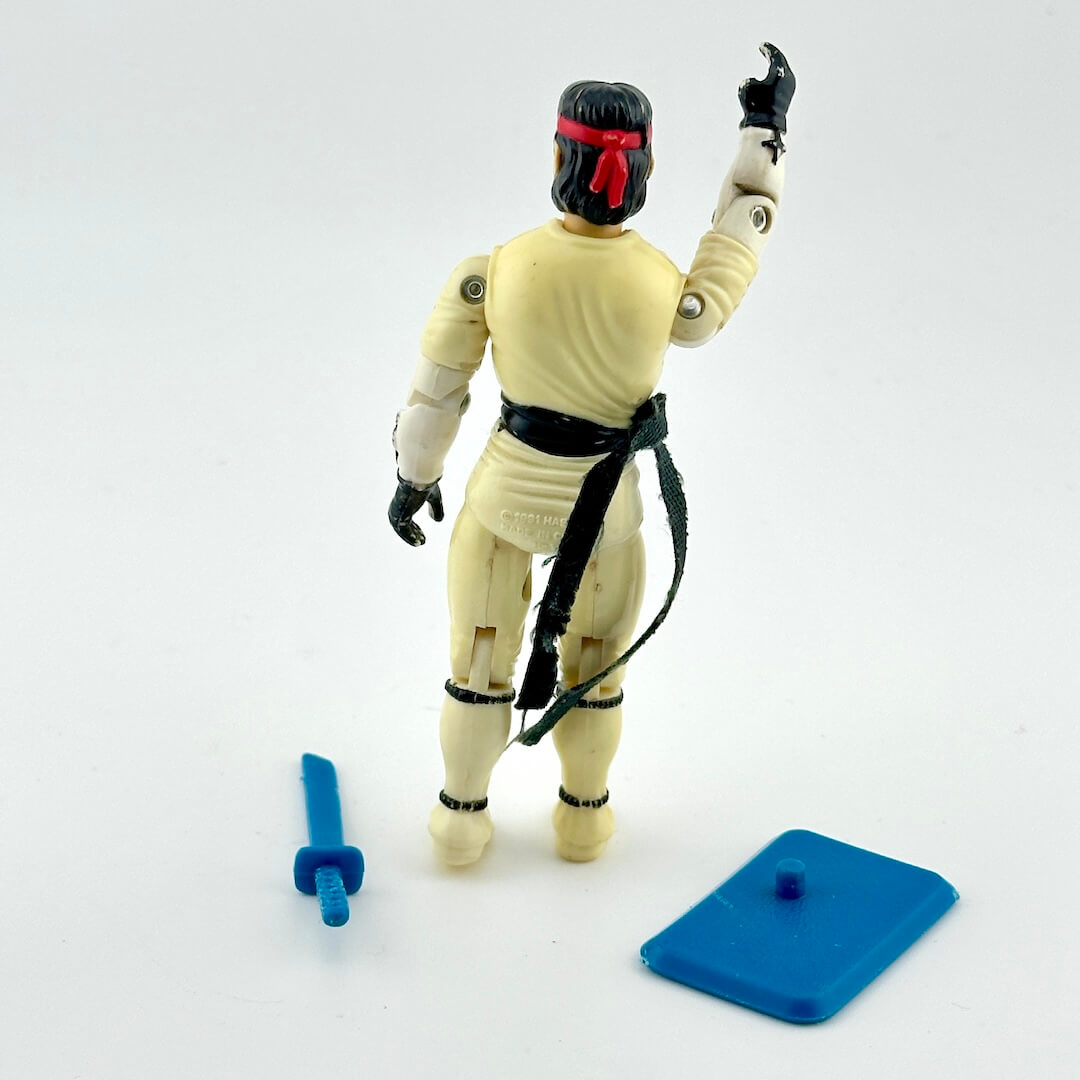 Action figure in martial arts costume with accessories against white background. 
