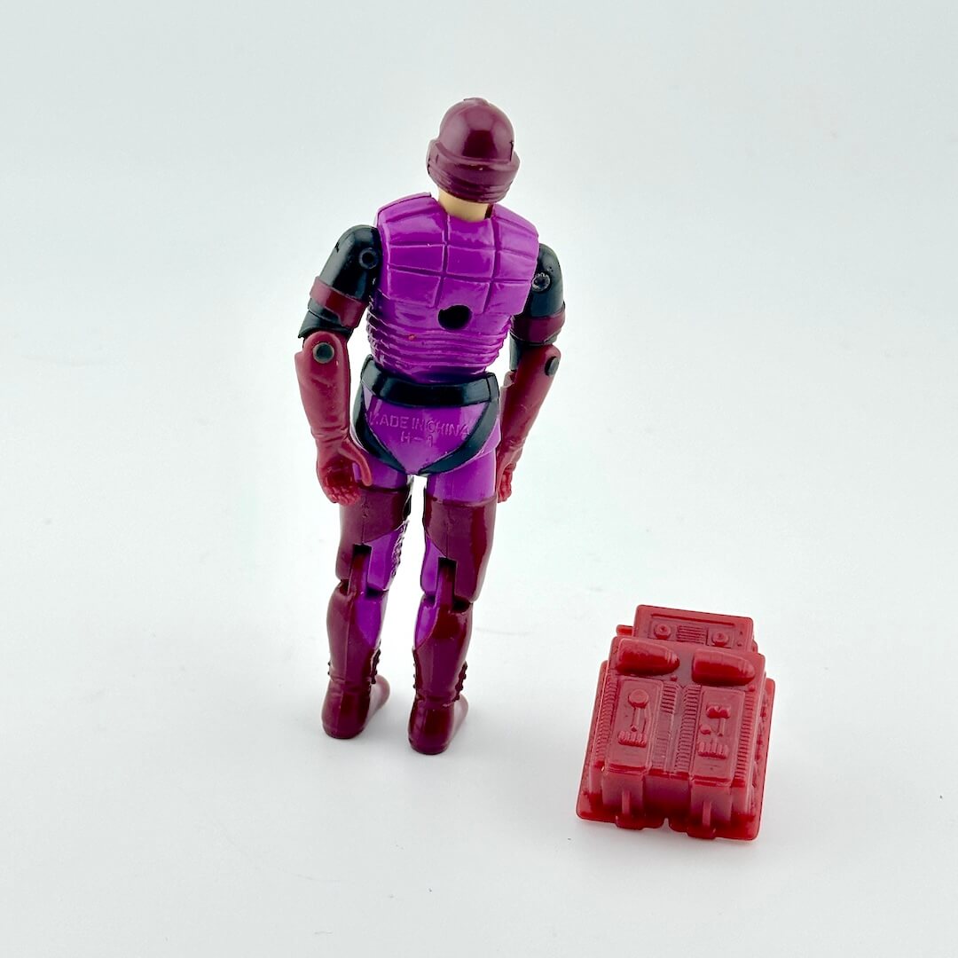 Toy figure in purple and red costume with a red toolbox on a white background