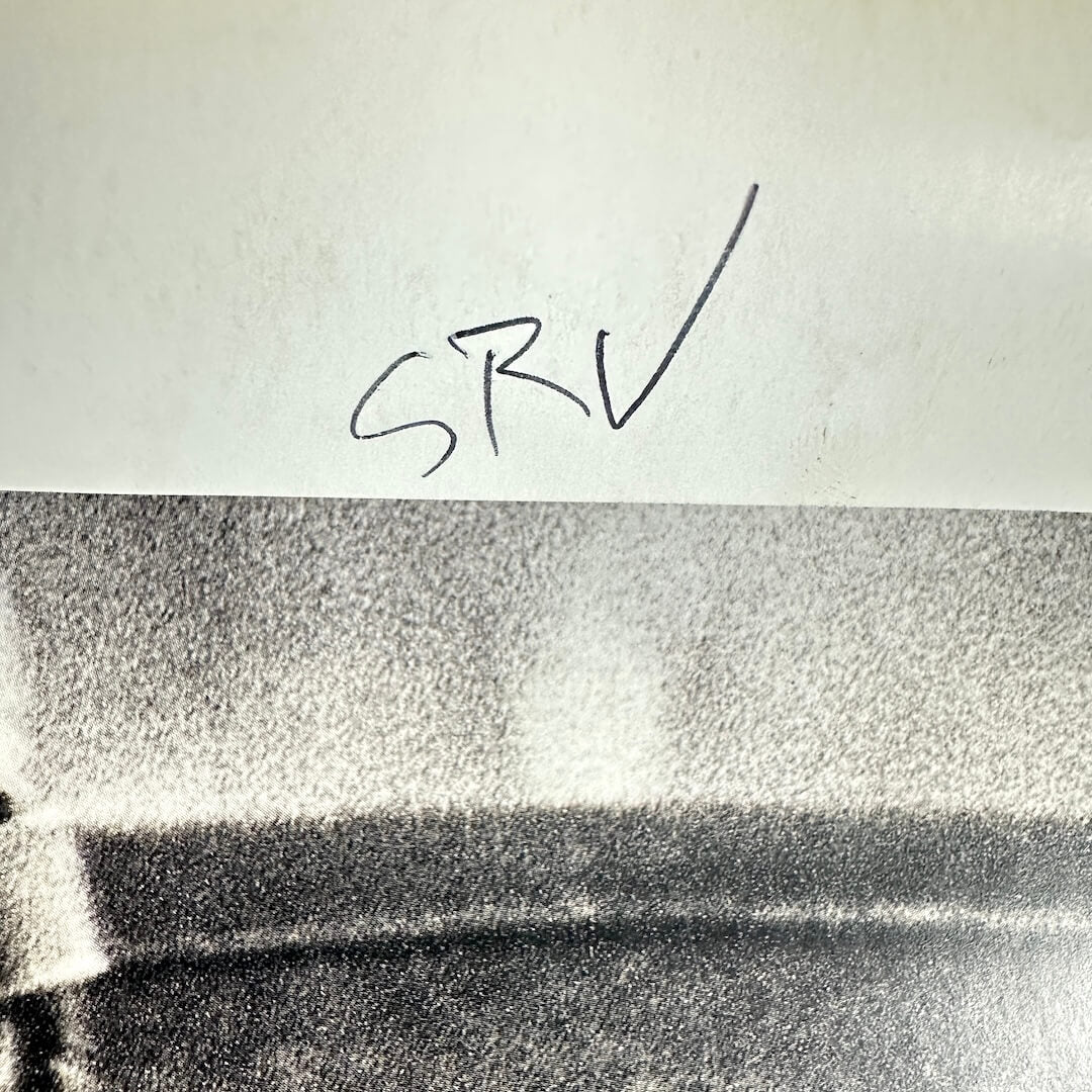 Backside of poster with "SRV" written in pen. 