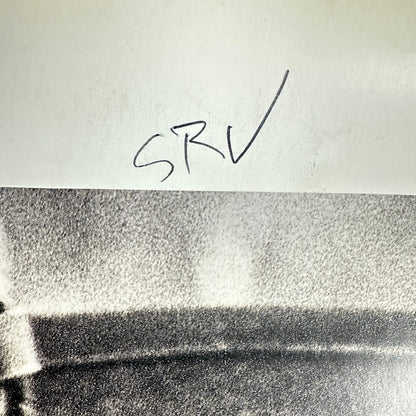 Backside of poster with "SRV" written in pen. 