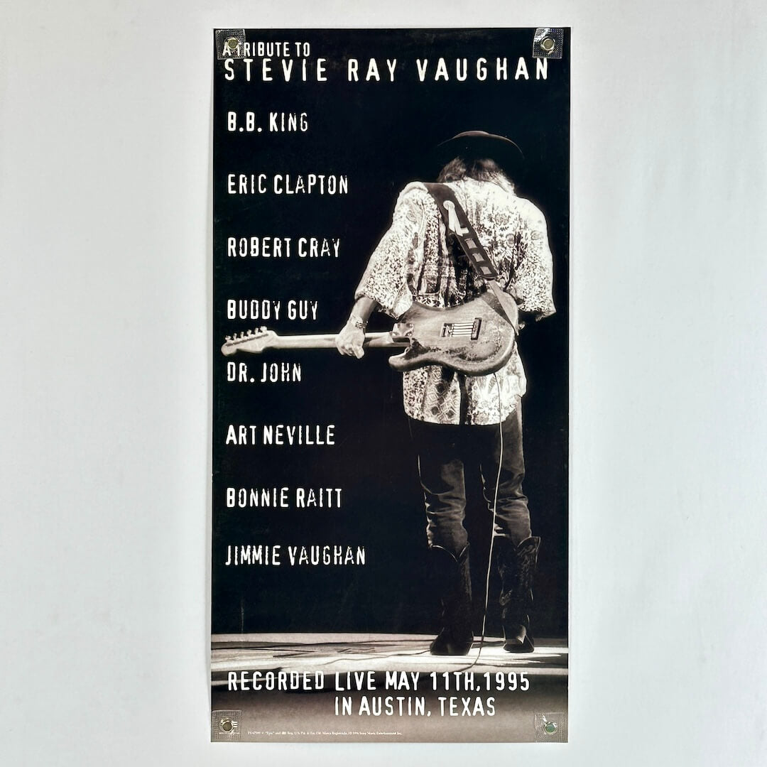 Poster tribute to Stevie Ray Vaughan featuring a musician with a guitar on a dark background.