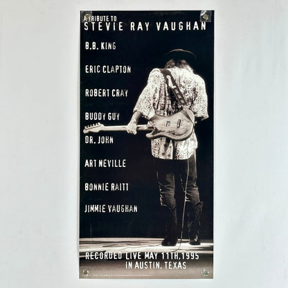 Poster tribute to Stevie Ray Vaughan featuring a musician with a guitar on a dark background.