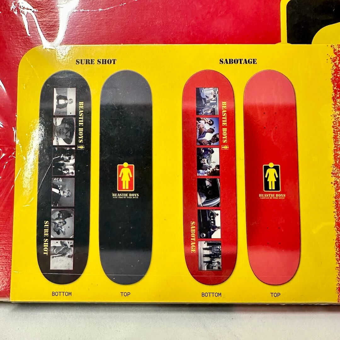 Close-up of skate deck options, one red with 6 photos, the other is black with six photos. 