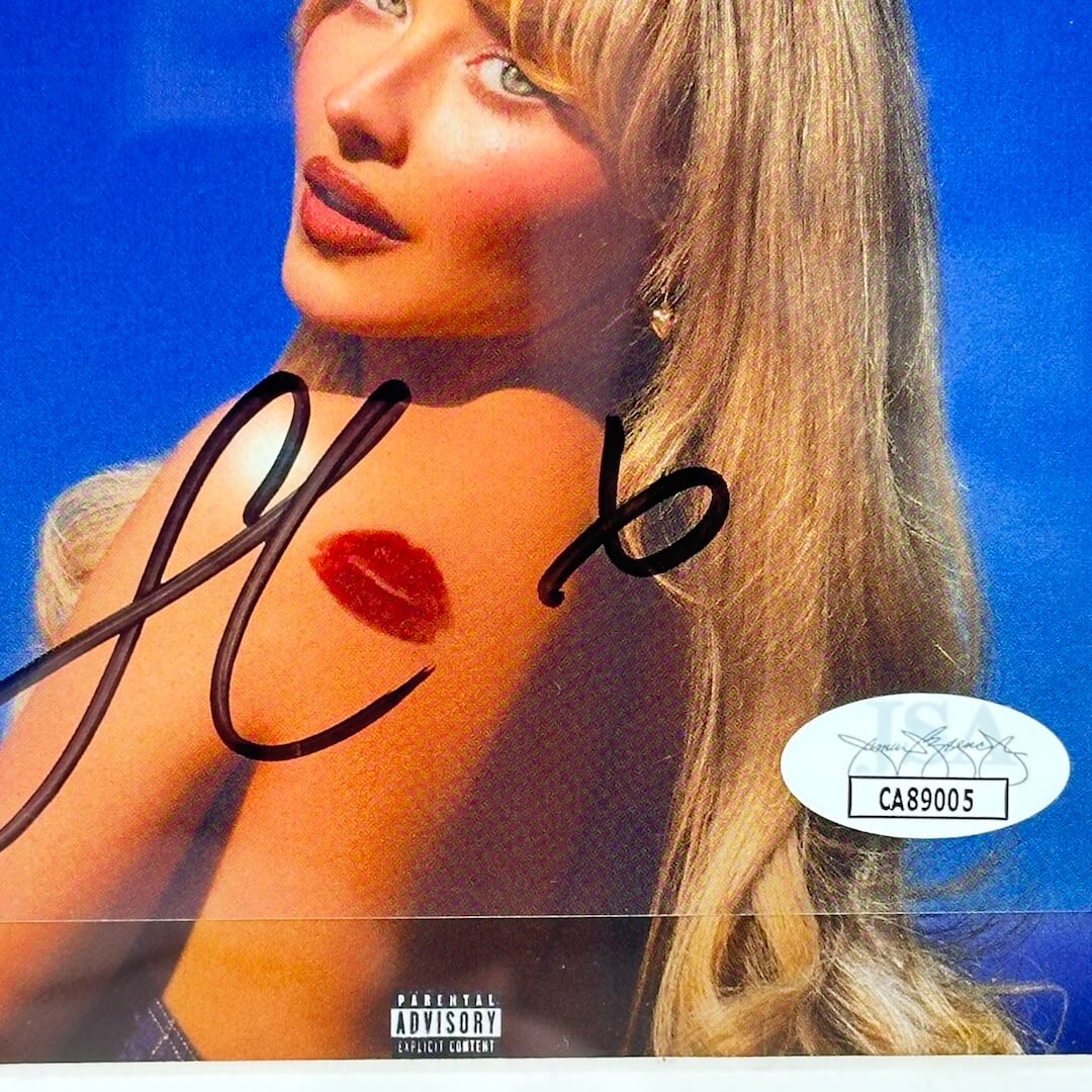 Album cover with a person's face, red lipstick mark, and 'JSA' logo on a blue background.