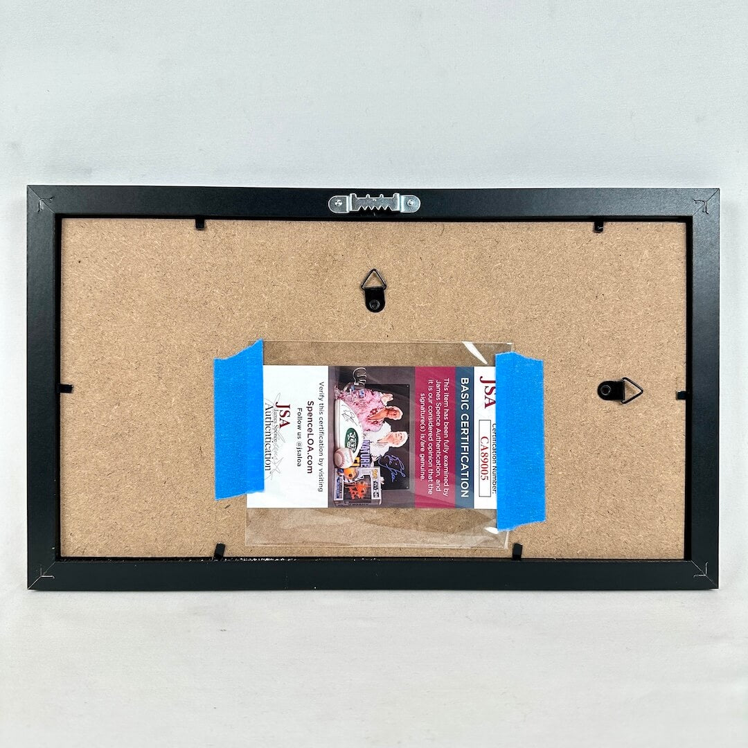 Back of a framed picture with JSA certification label.