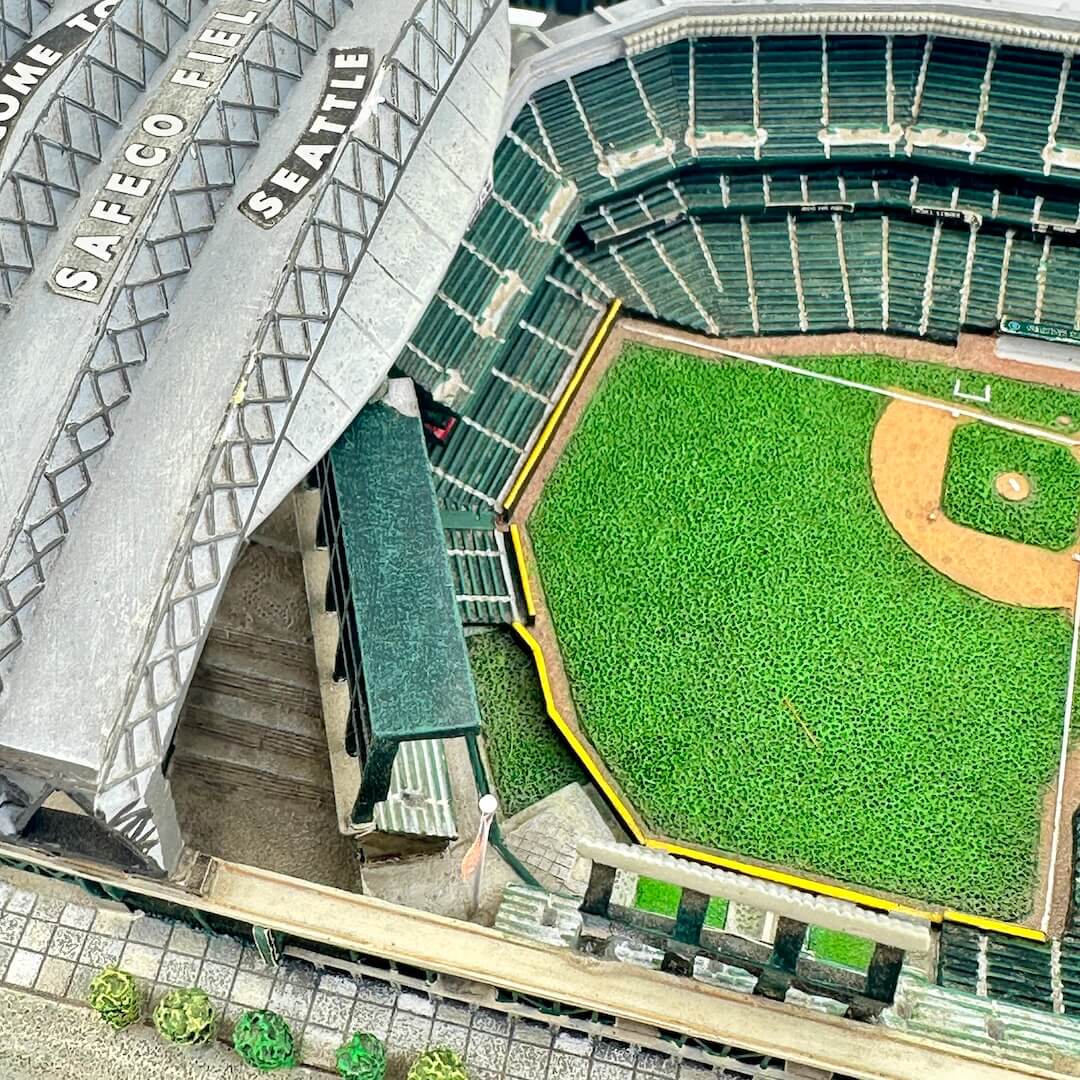 Aerial view of a baseball stadium with a green field and seating area.