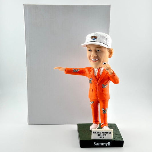 Bobblehead of man in orange suit with white box on white background. 