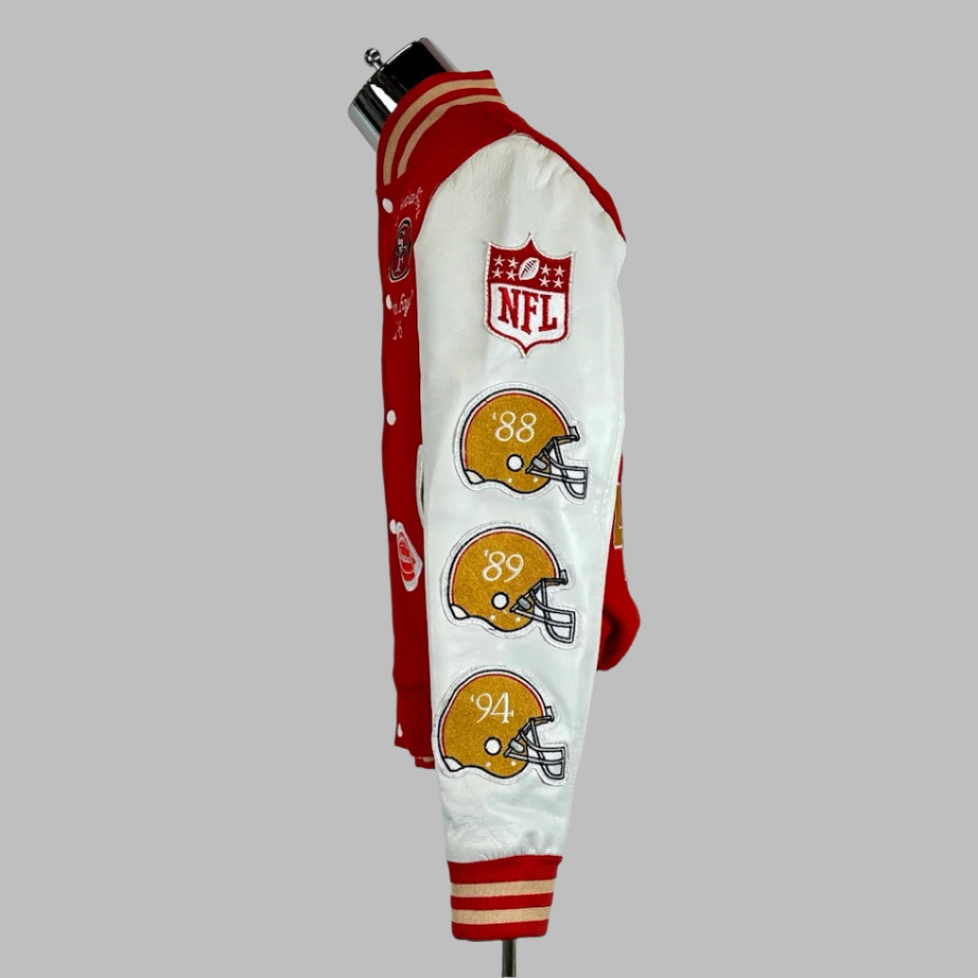 Side view Backside of varsity jacket with red body, white sleeves with three helmet patches down sleeve under NFL shield. 
