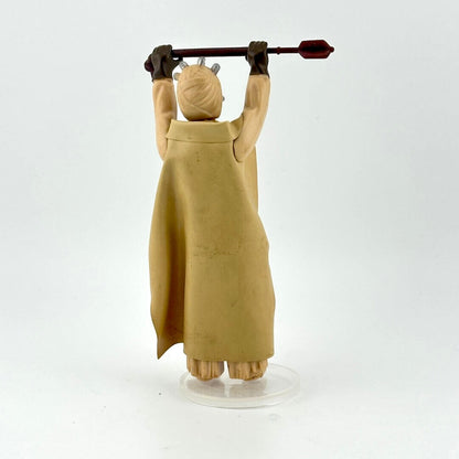 Action figure of Sand Person holding stick aloft in long tan cloak against white background
