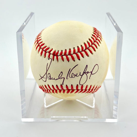 Singed baseball in clear display cube against white background. 