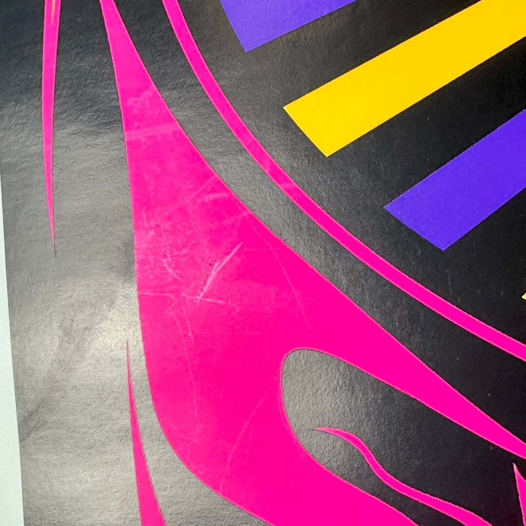 Close-up of light scratches to one section of poster. 