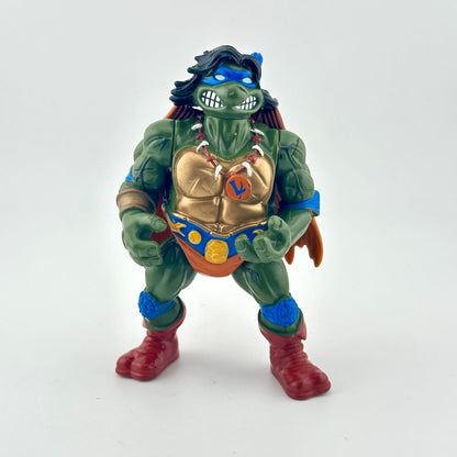 Toy figure of a green turtle with a gold chest piece on a white background