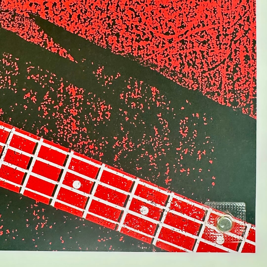 Close-up of a red guitar fretboard with black and red abstract pattern in the background