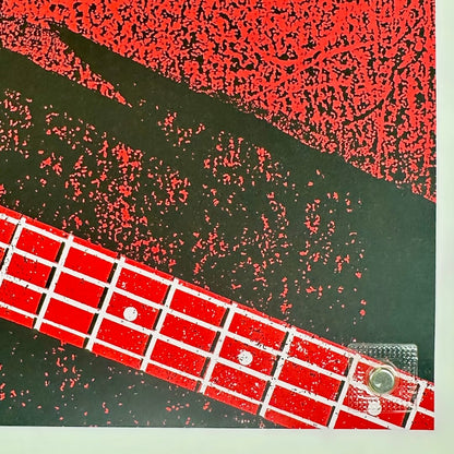 Close-up of a red guitar fretboard with black and red abstract pattern in the background