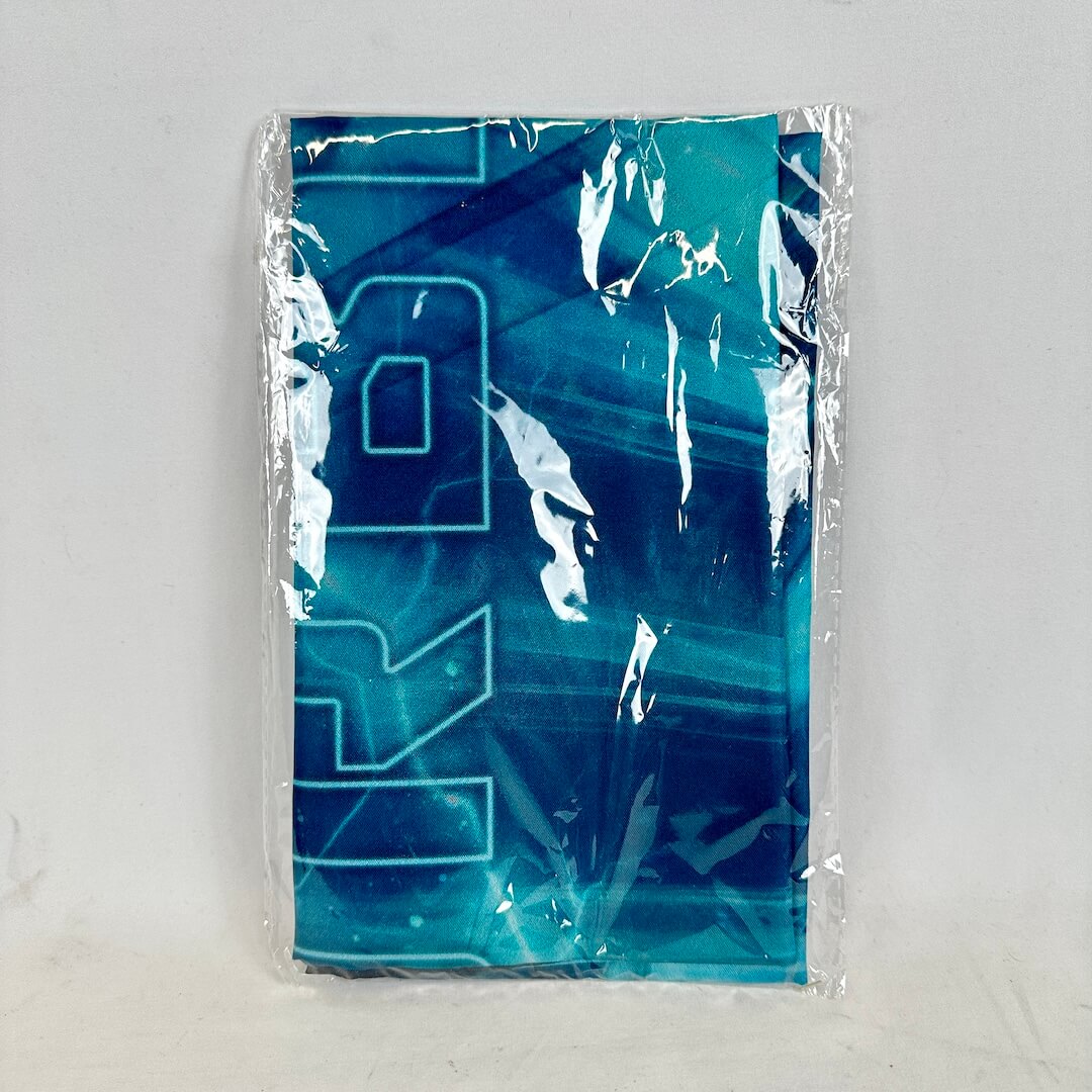Blue and white patterned fabric in a clear plastic bag on a light gray background