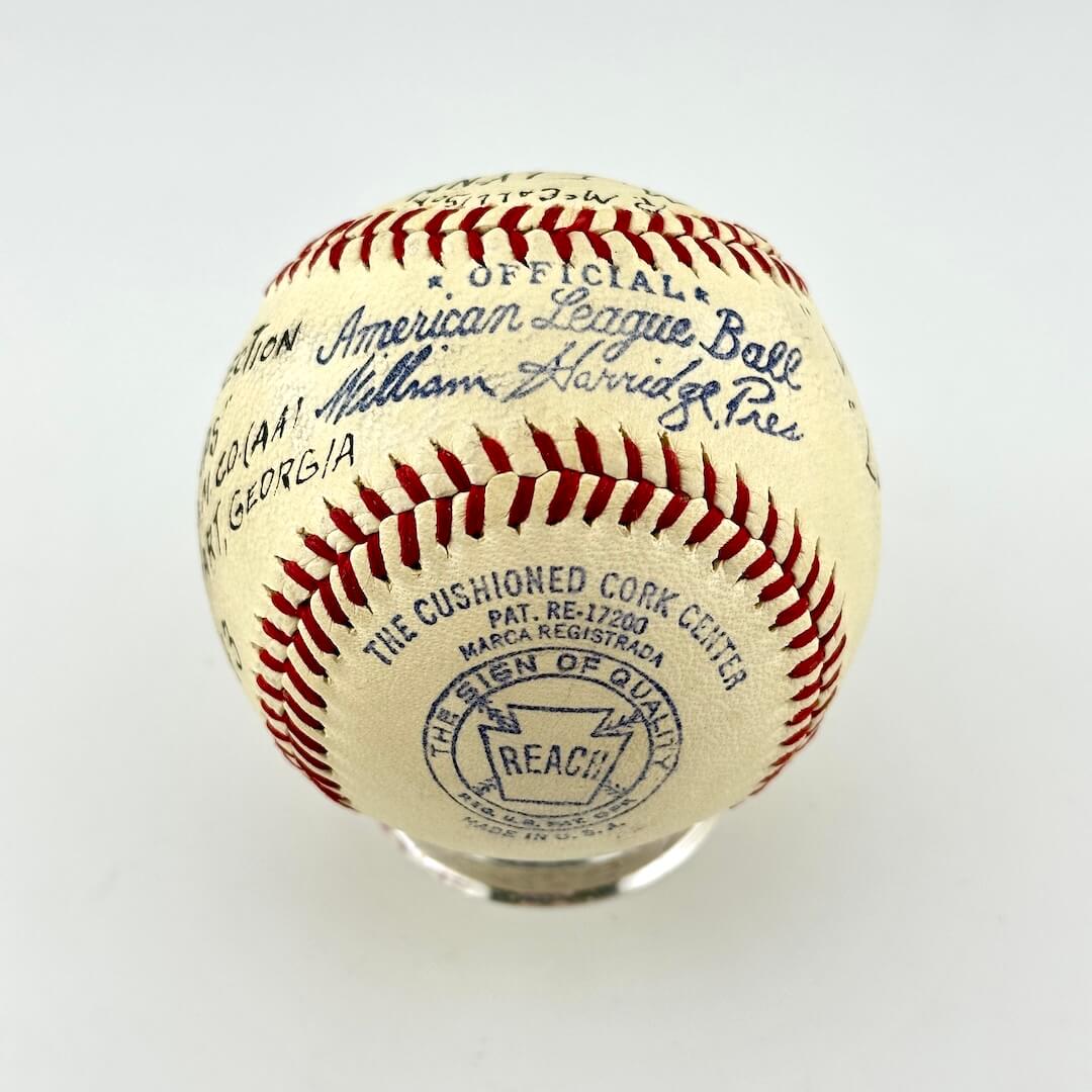 An official American League baseball on a clear display stand, featuring red stitching, blue printed text.