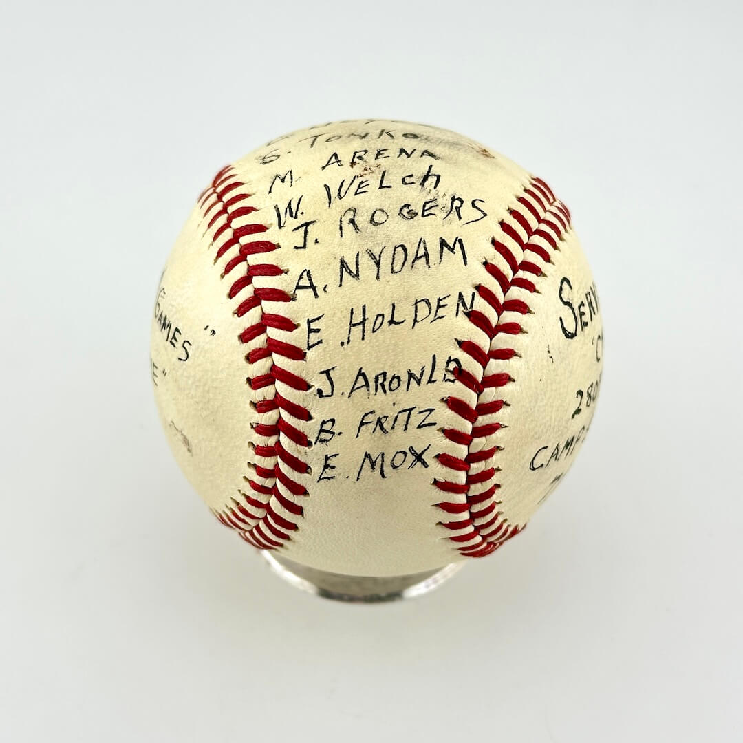 A white leather baseball with red stitching, signed with black ink names. 