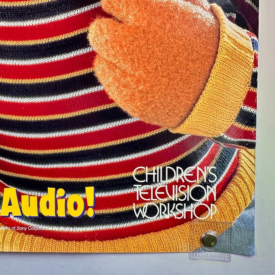 Children's Television Workshop logo on a colorful striped shirt with a hand wearing an orange glove.