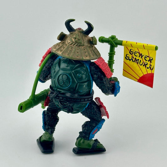 Samurai dressed anthropomorphized turtle with red & blue detailing on armor, green accessories. Back.
