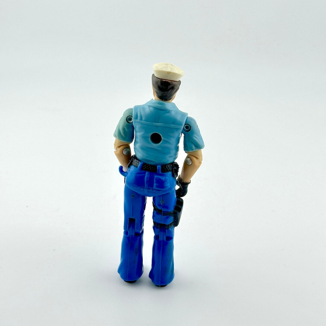 Toy figure of a police officer in blue uniform on a white background