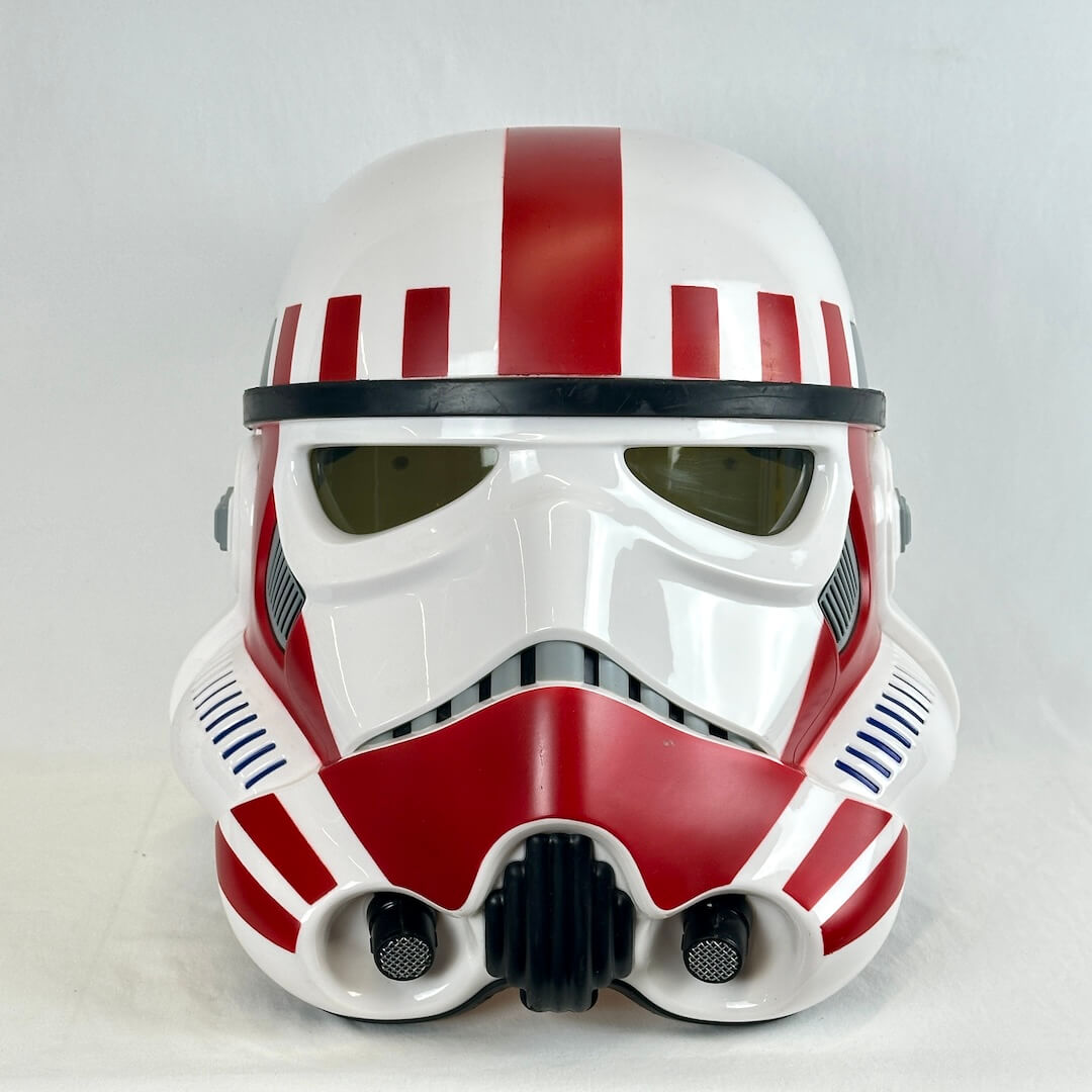 A white and red sci-fi helmet replica with black visor details, photographed against a plain light gray background.