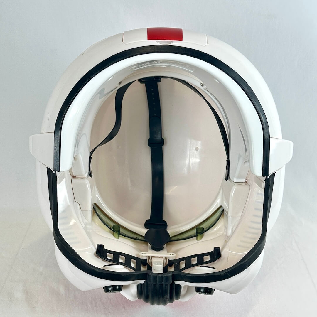 A white sci-fi style helmet shown from the inside, featuring black trim, a black interior strap.