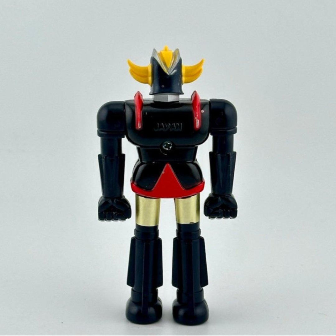 Back of robot action figure with black body with JAPAN across back of shoulders.