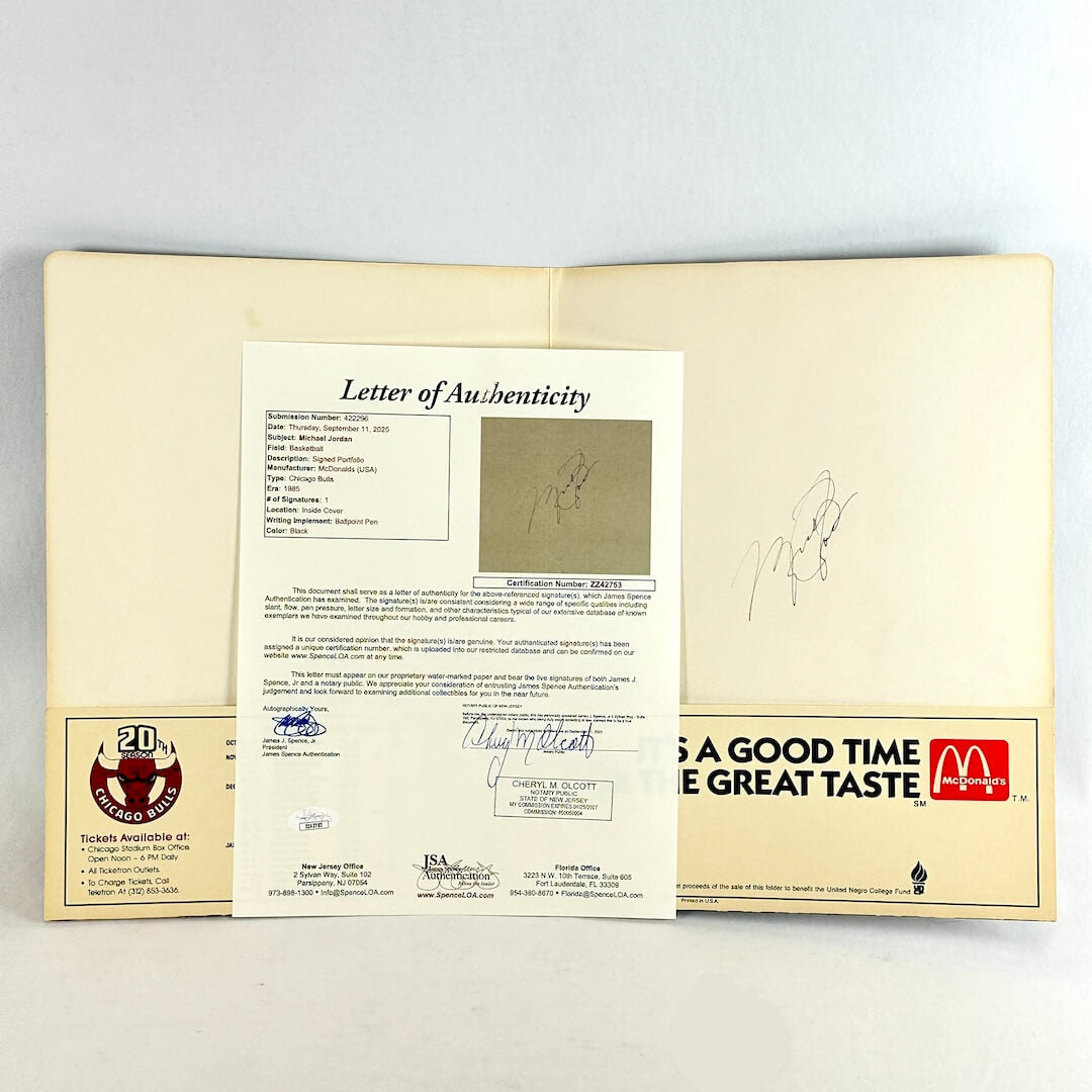 Letter of Authenticity document in front of folder with signature against light gray background. 