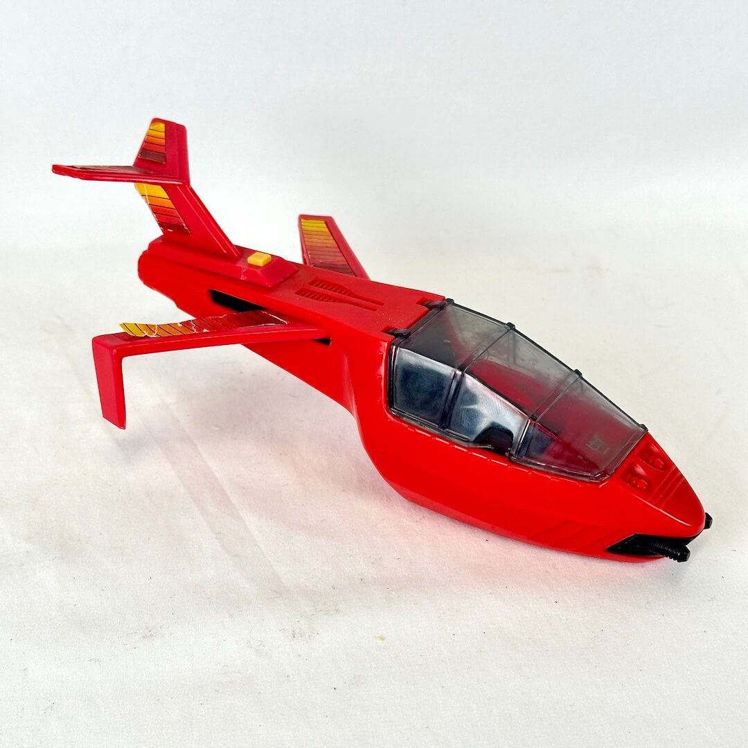 A red toy jet airplane with a clear canopy cockpit.