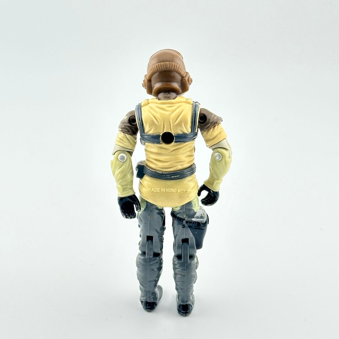Action figure in flight suit against white background. 