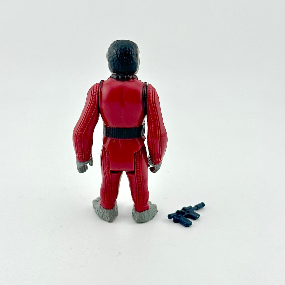 Toy figure in a red suit with a black helmet on a white background