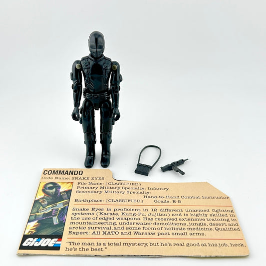 Black action figure with accessories and a card on a white background