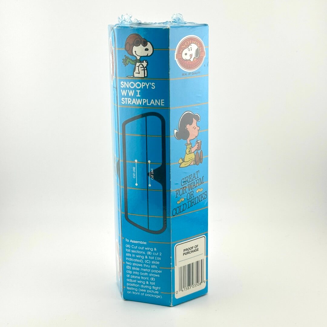 A cylindrical blue box with design for Snoopy's WWI Strawplane with cartoon illustrations. 
