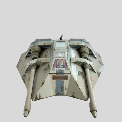 A vintage Star Wars model, featuring a weathered gray and black paint scheme with a visible figure inside the cockpit.