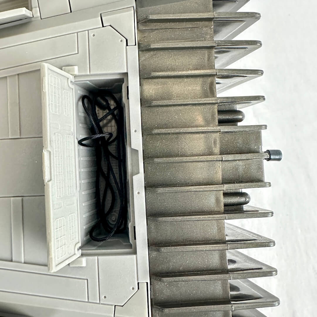 Close-up of open compartment on underside of oy vehicle with coiled thread inside. 