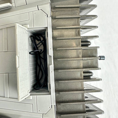 Close-up of open compartment on underside of oy vehicle with coiled thread inside. 